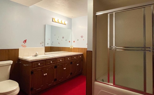 17850 Cedar Park Loop, Fergus Falls, MN 56537 - bathroom with wainscoting, toilet, vanity, shower / bath combination with glass door, and wood walls