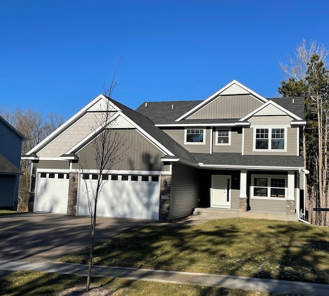 view of front of house featuring a garage, covered porch, and a front yard