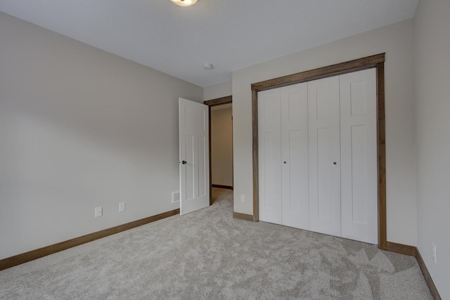 unfurnished bedroom featuring light colored carpet and a closet