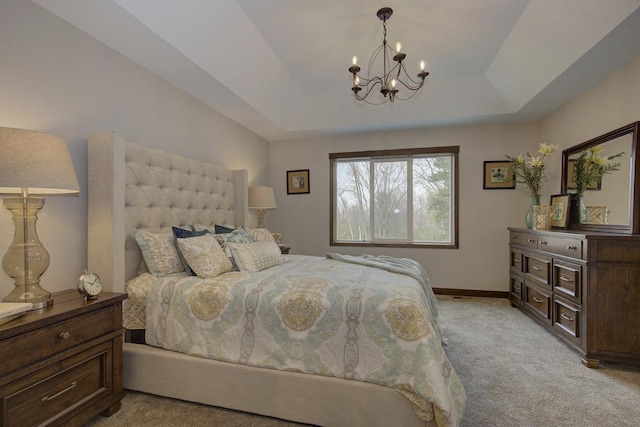 carpeted bedroom with a notable chandelier and a tray ceiling