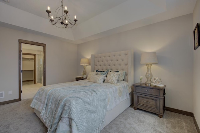 bedroom featuring a tray ceiling, a chandelier, a closet, light colored carpet, and a spacious closet