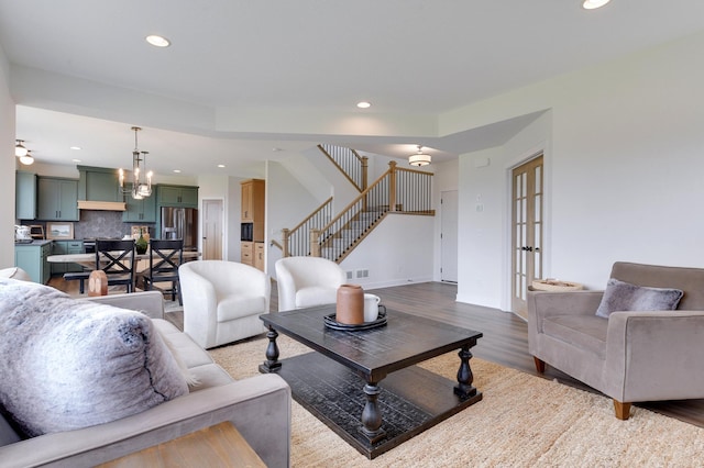 living room with french doors, wood-type flooring, and a chandelier