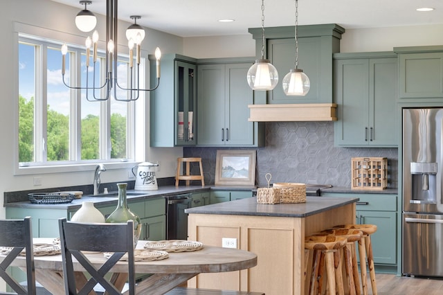 kitchen featuring black dishwasher, wood-type flooring, sink, stainless steel fridge with ice dispenser, and a center island