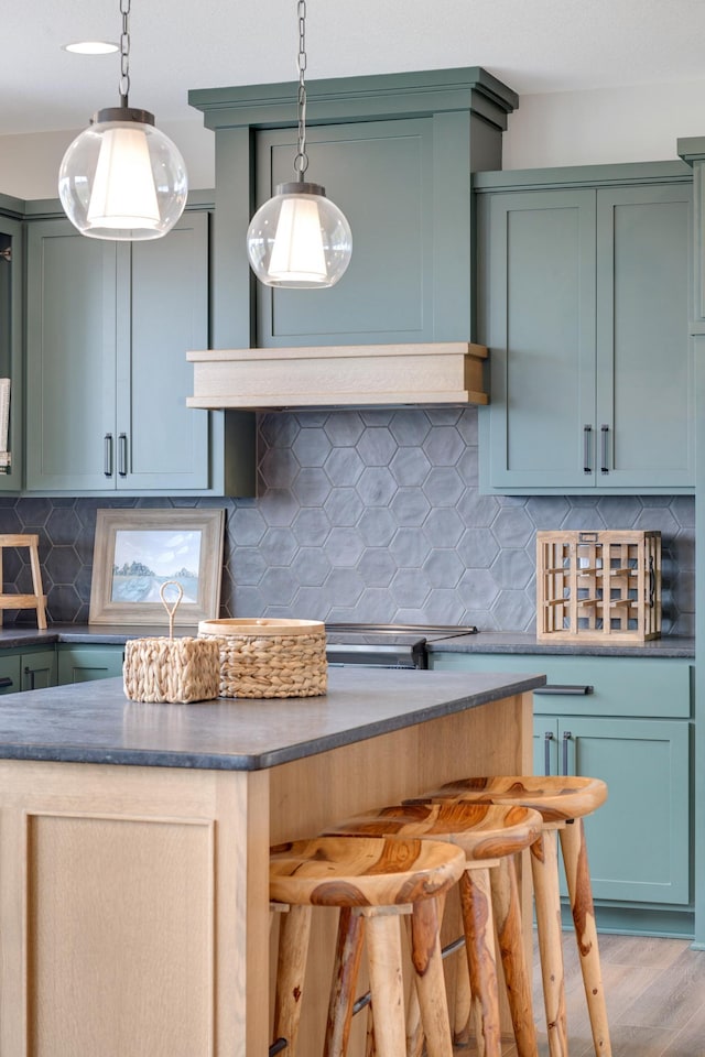 kitchen with hanging light fixtures, wood-type flooring, and backsplash