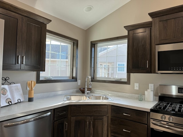 kitchen featuring appliances with stainless steel finishes, sink, vaulted ceiling, and plenty of natural light