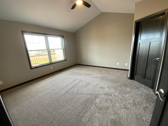 unfurnished bedroom featuring vaulted ceiling, light carpet, and ceiling fan