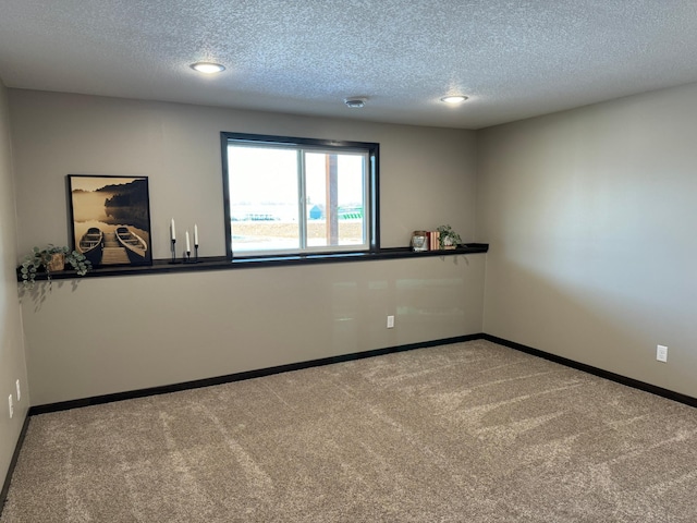 unfurnished room with carpet and a textured ceiling