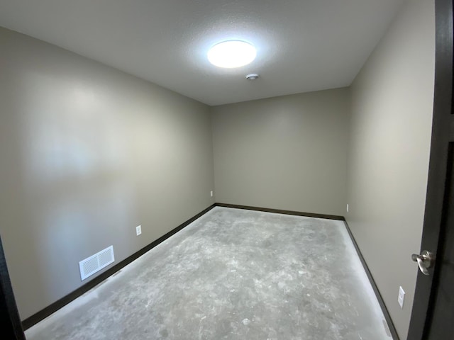 unfurnished room with concrete floors and a textured ceiling