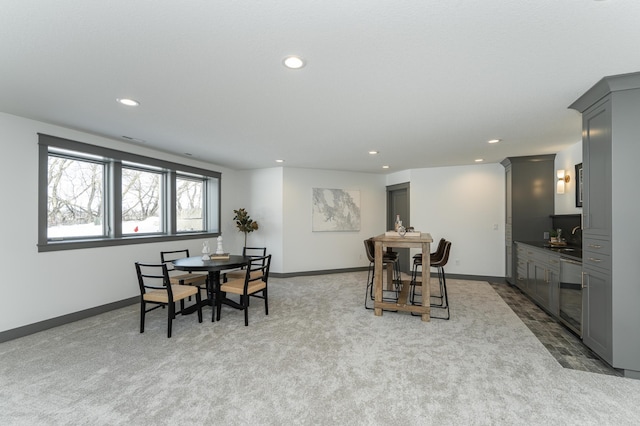 dining space with baseboards, recessed lighting, and light colored carpet