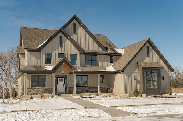 modern farmhouse style home with board and batten siding, stone siding, and roof with shingles