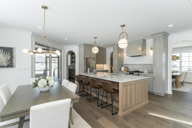 kitchen featuring arched walkways, stainless steel appliances, extractor fan, and gray cabinets