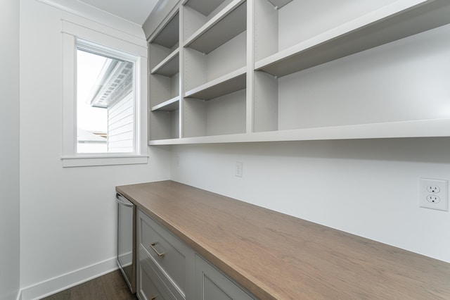 unfurnished office featuring dark wood-style flooring and baseboards