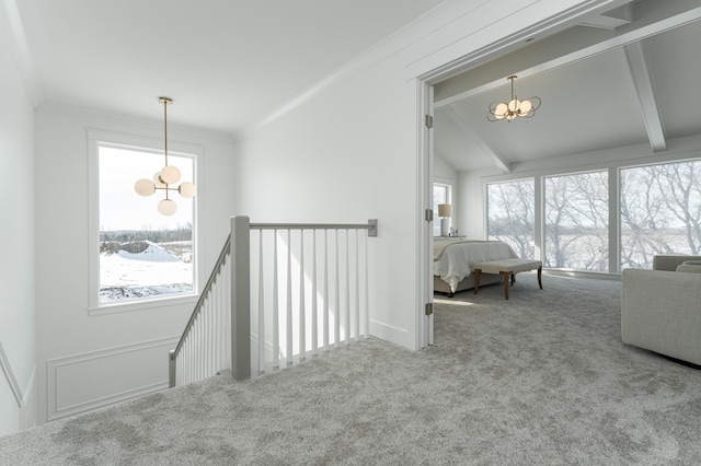 hall with lofted ceiling with beams, an upstairs landing, an inviting chandelier, crown molding, and carpet flooring