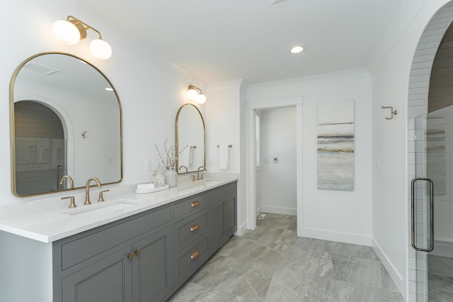 bathroom featuring ornamental molding, an enclosed shower, a sink, and double vanity