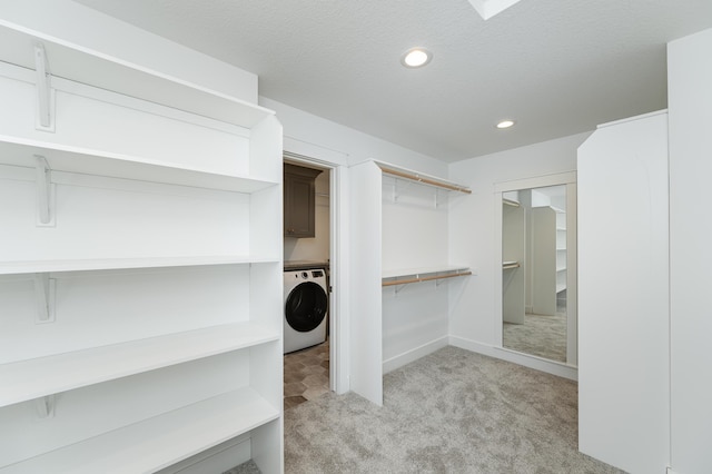 spacious closet featuring light carpet and washer / clothes dryer