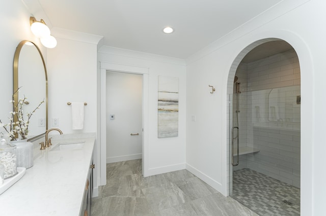 bathroom with double vanity, crown molding, a sink, and a shower stall