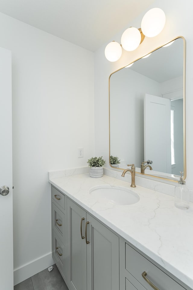 bathroom featuring tile patterned flooring, baseboards, and vanity