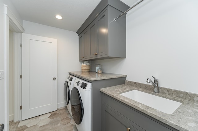 washroom with washing machine and dryer, a sink, cabinet space, and recessed lighting