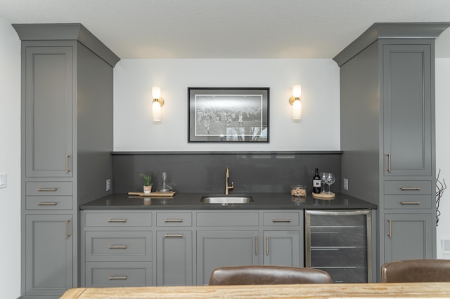 bar with wine cooler, decorative backsplash, a sink, and wet bar