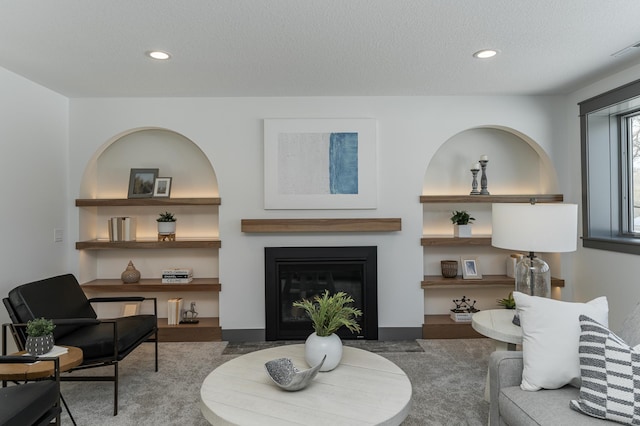 living room featuring a fireplace with flush hearth, recessed lighting, and a textured ceiling