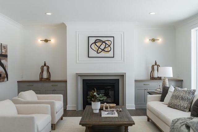 living room featuring ornamental molding, recessed lighting, a glass covered fireplace, and light wood-style floors