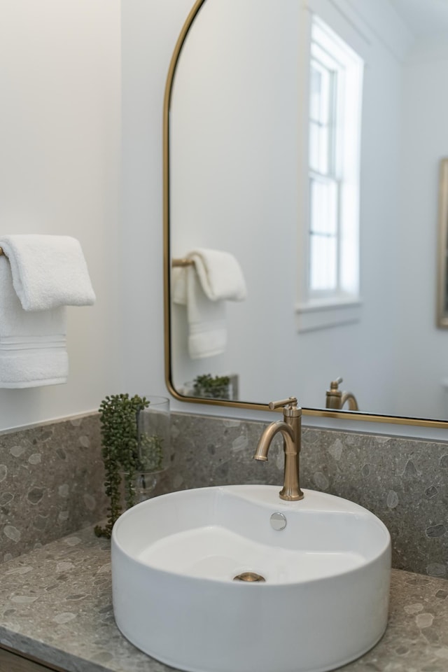 bathroom featuring a wainscoted wall, a sink, and tile walls