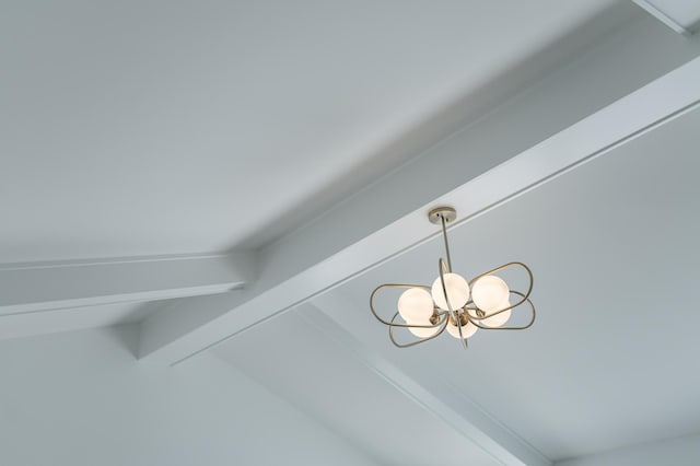 details featuring a chandelier and beam ceiling