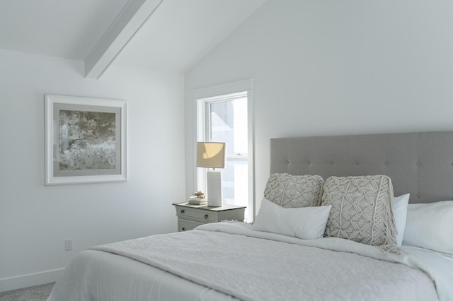 carpeted bedroom featuring lofted ceiling with beams and baseboards