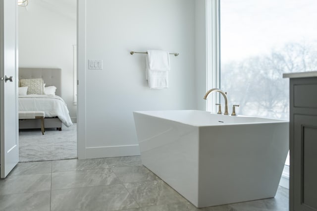 full bath with a freestanding tub, baseboards, and ensuite bathroom