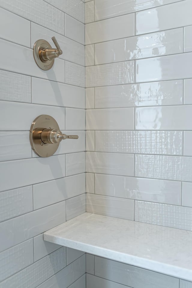 interior details featuring a tile shower