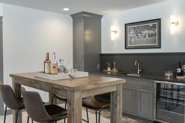 bar featuring a sink, wine cooler, indoor wet bar, and recessed lighting