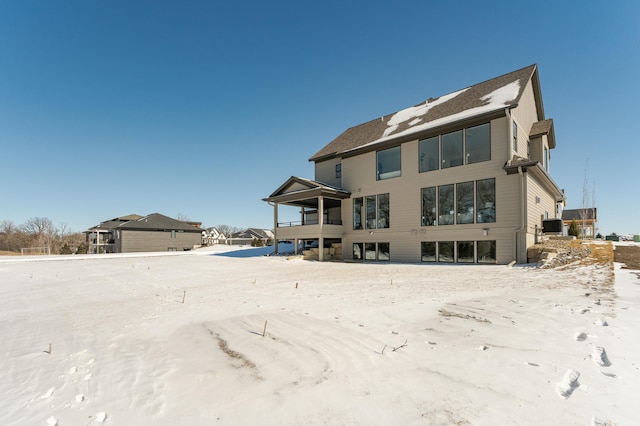 view of snow covered rear of property