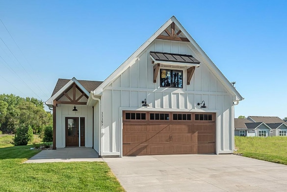 modern farmhouse with a front lawn and a garage