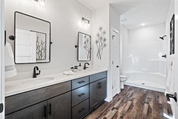 bathroom with a shower, wood-type flooring, toilet, and vanity