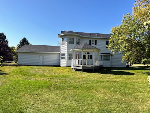 rear view of house featuring a deck and a yard