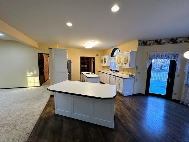 kitchen featuring white cabinets, dishwasher, a center island, and dark hardwood / wood-style flooring