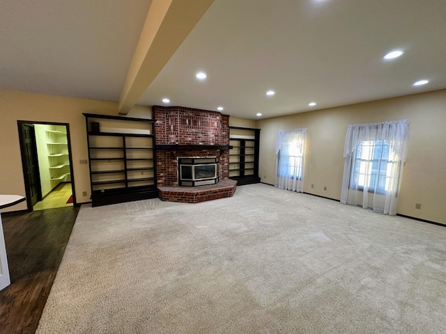 unfurnished living room featuring beam ceiling and dark carpet