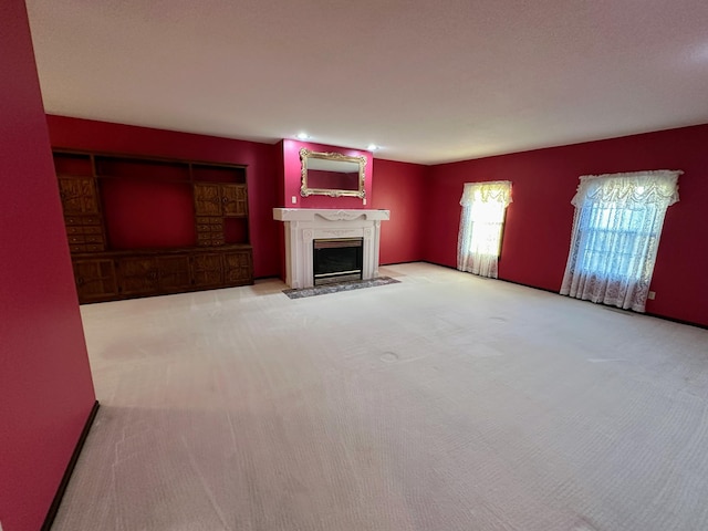 unfurnished living room featuring light carpet and a fireplace