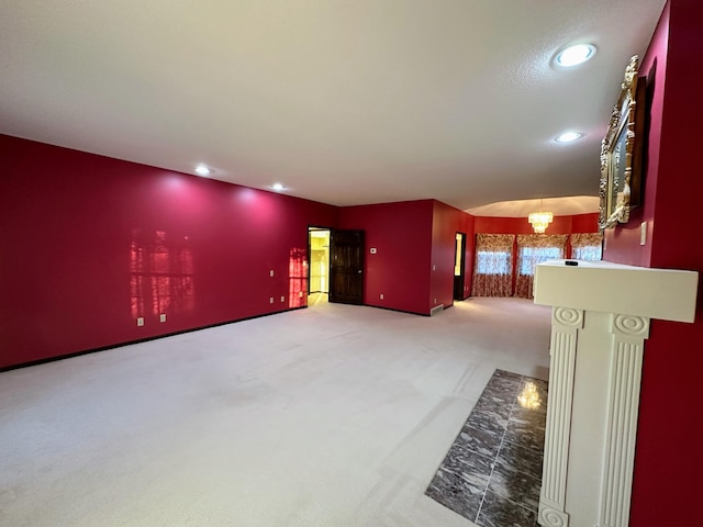 unfurnished living room with carpet and an inviting chandelier