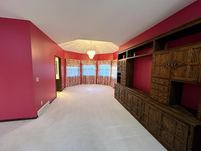 hall with carpet floors and an inviting chandelier