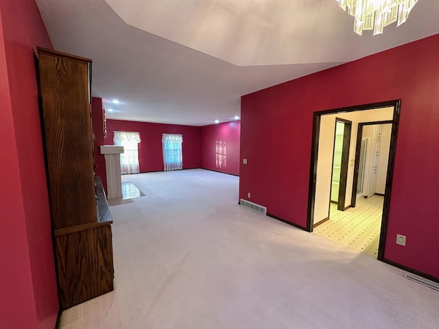 interior space featuring light colored carpet and a notable chandelier