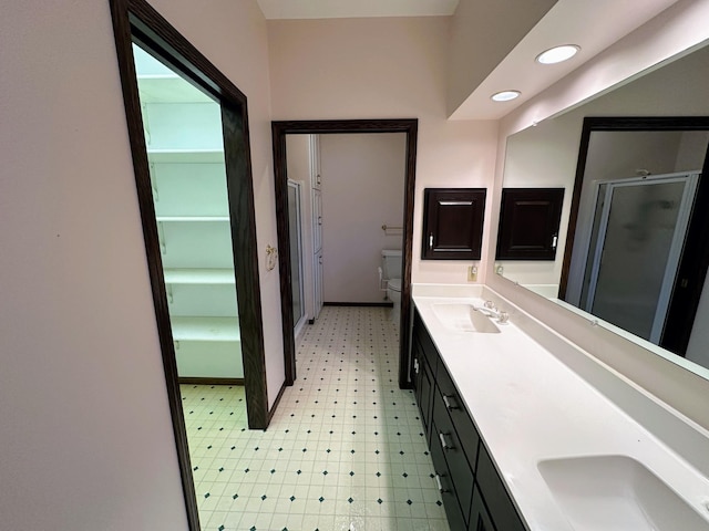 bathroom featuring vanity, toilet, and an enclosed shower