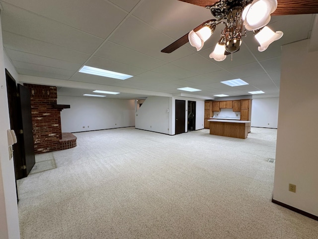 unfurnished living room featuring light carpet, a brick fireplace, and a drop ceiling