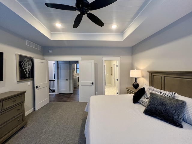 carpeted bedroom featuring ceiling fan and a raised ceiling