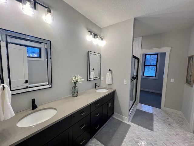 bathroom with walk in shower, tile flooring, double sink, a textured ceiling, and oversized vanity