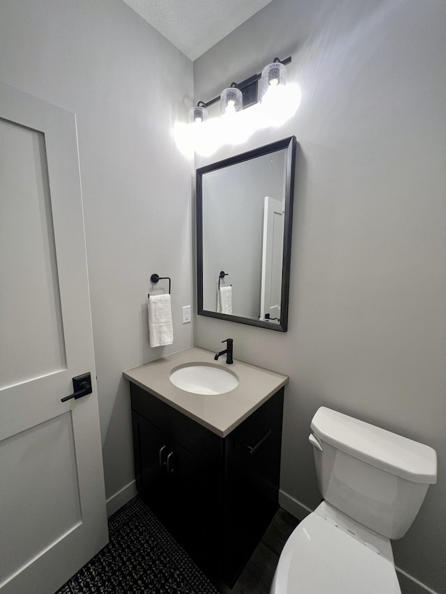 bathroom with tile floors, toilet, and vanity