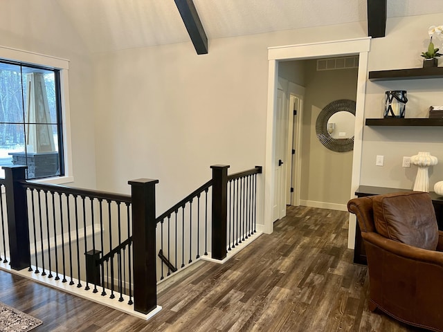 hallway featuring dark wood-type flooring and vaulted ceiling with beams