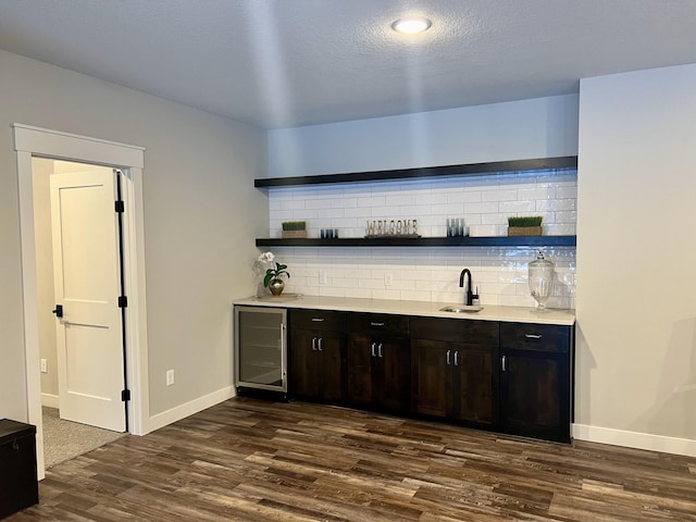 bar with beverage cooler, tasteful backsplash, and dark wood-type flooring