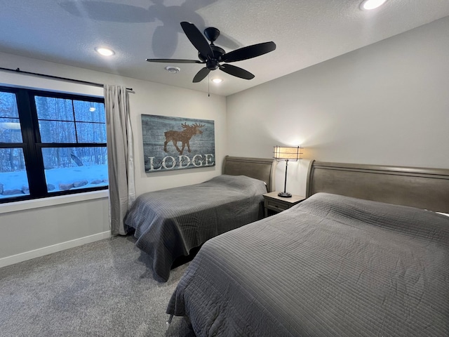 carpeted bedroom featuring ceiling fan and a textured ceiling