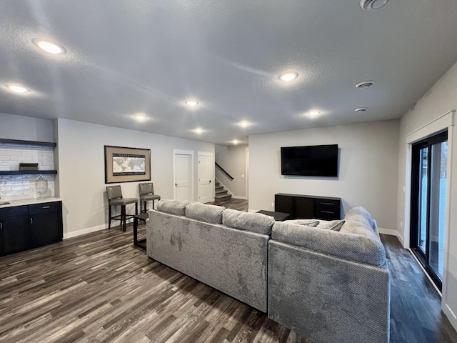 living room featuring a textured ceiling and dark hardwood / wood-style floors